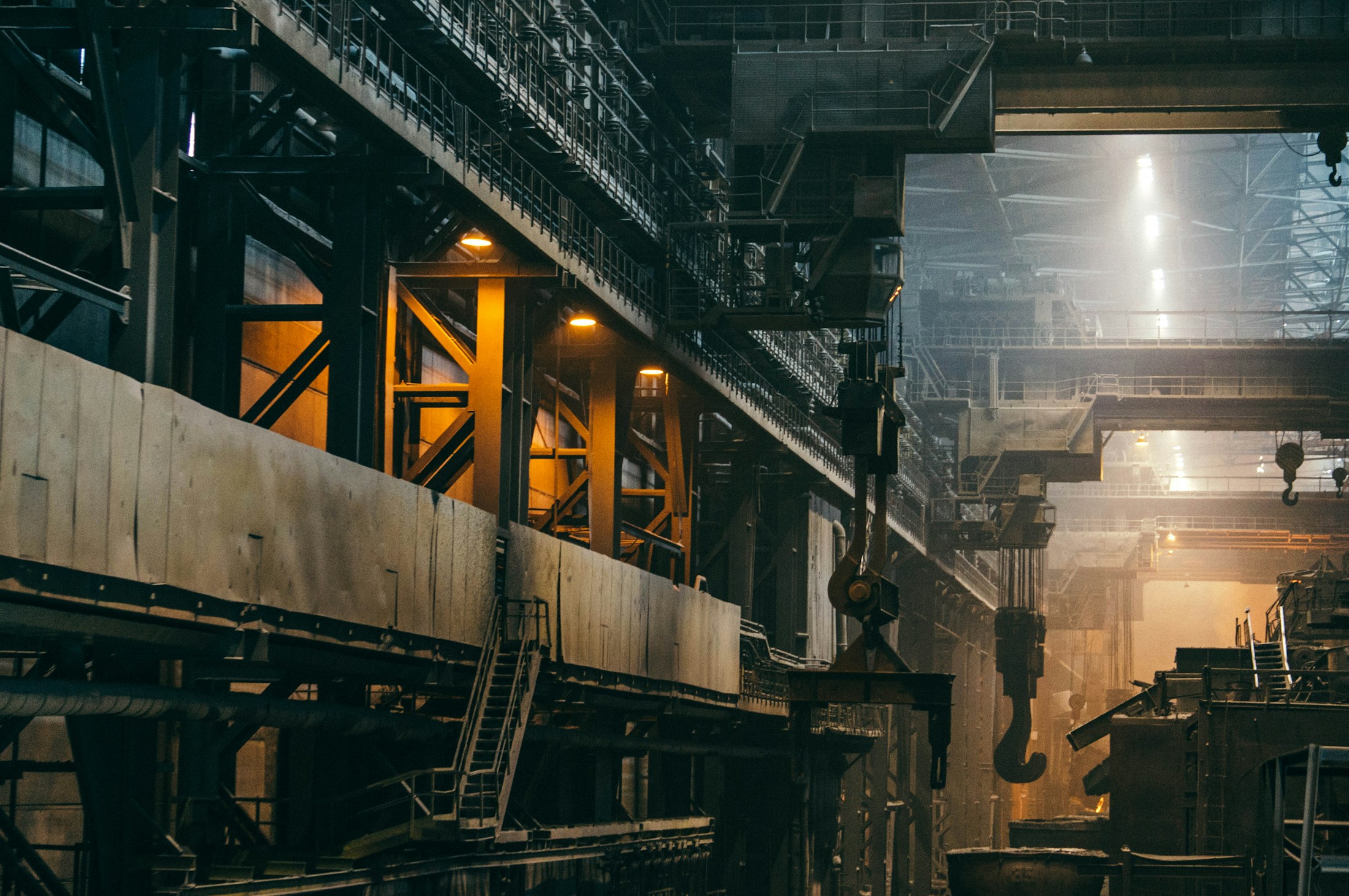 Industrial production hall with overhead cranes and warm workshop lighting